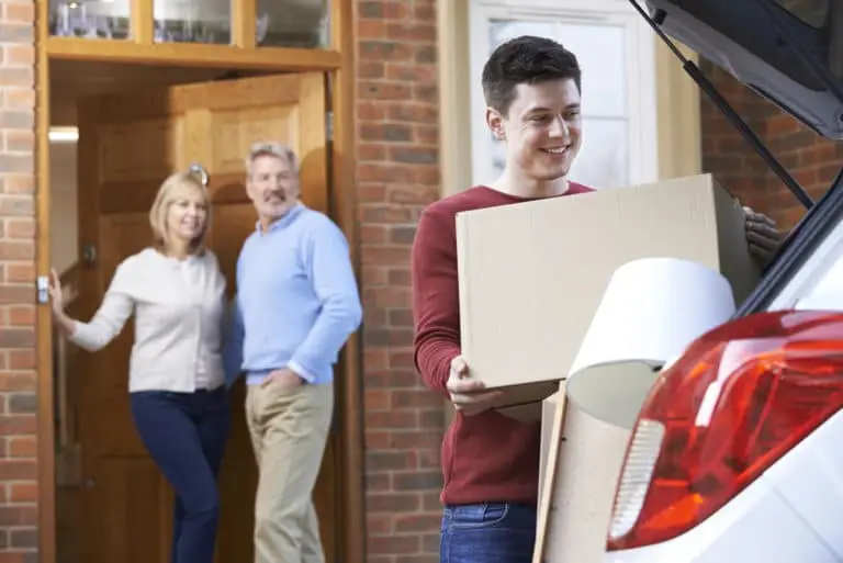 a man carrying a box in the back of a car