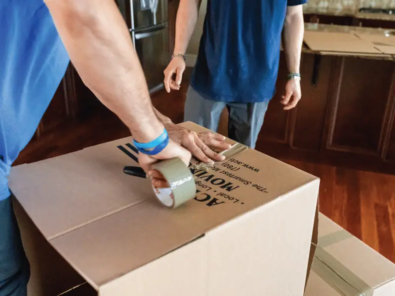 Mover taping a moving box