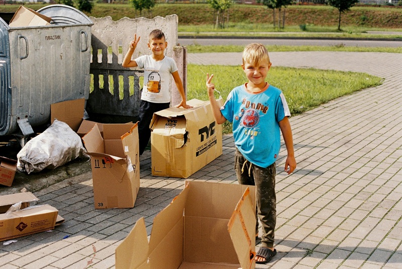 Children playing with cardboard boxes outdoors