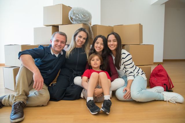 Family sitting on floor with moving boxes